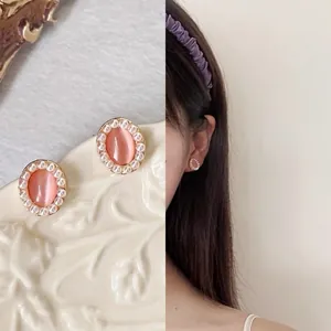 Vintage oval cat's eye earrings with pearl border detail and model wearing view
