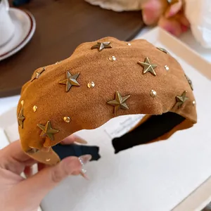 Macro view of brown suede padded headband decorated with golden stars and crystals