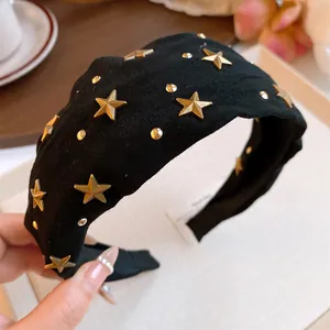 Macro detail of golden star and round studs on a black velvet designer headband