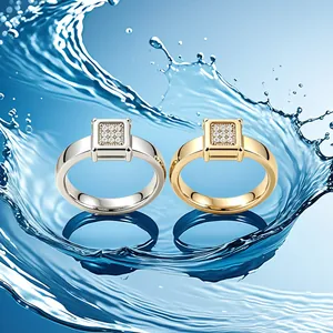 Vista dettagliata di anelli pavé quadrati in argento e oro su sfondo di schizzi d'acqua blu.
