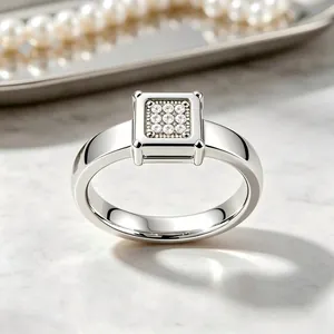 Dettaglio di un anello in acciaio inossidabile argento con diamanti quadrati.