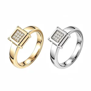Dettaglio di anelli in acciaio inossidabile con cristalli quadrati oro e argento per coppie.
