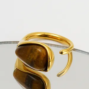 Nahaufnahme eines goldenen Edelstahlrings mit poliertem Tigerauge-Stein im Detail.