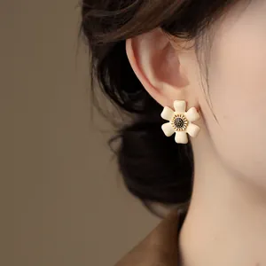 Close-up of a French vintage enamel flower stud earring worn on a female ear
