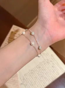 Nahaufnahme eines eleganten zweilagigen Armbands mit weißen Perlen und Kristallperlen