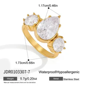 Macro view of a gold-plated stainless steel ring with three large clear cubic zirconias.