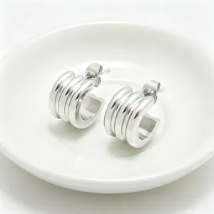 Detailed close-up view of minimalist stainless steel triple-layered C-shaped hoop earrings