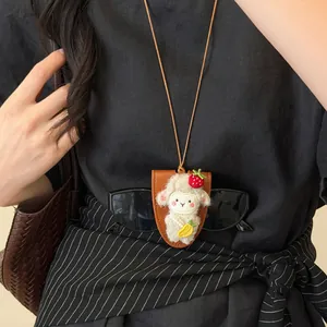 Detalle de un collar con clip magnético para gafas con diseño de cordero sobre top negro.