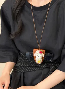 Detalle del collar con clip magnético para gafas con forma de oveja en suéter negro
