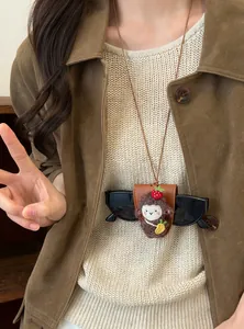 Detalle del collar magnético portagafas de ovejita linda en modelo con gafas de sol