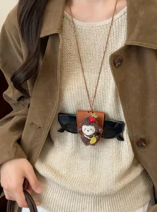 Detalle del collar porta gafas magnético de oveja fresa con cordón marrón