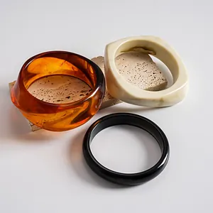 Gedetailleerde macro-opname van gemarmerde acryl mode-armbanden op een stenen voet