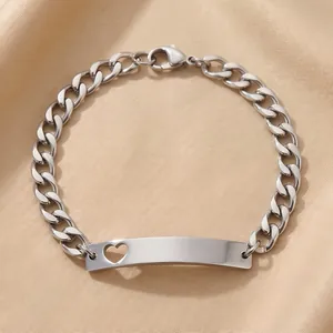 Detalle de pulsera de cadena cubana de acero con placa de identificación y corazón