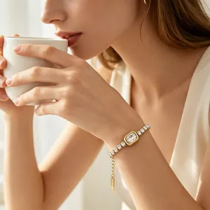 Elegante bracciale tennis placcato oro con gemma quadrata mostrato sul polso di una donna