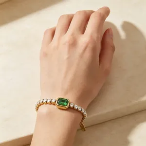 Dettaglio di un bracciale tennis placcato oro con gemma verde taglio smeraldo