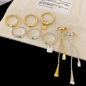 Macro view of vintage style jewelry set with water drop tassel earrings and gem rings
