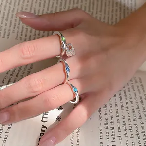 Detailed view of silver vintage ring set with colorful stones on a hand over book pages