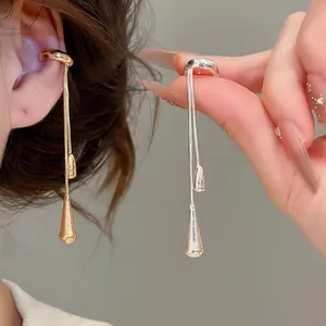 Close-up of elegant gold and silver teardrop tassel ear cuffs with sleek metallic finish