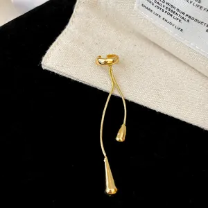 Detail view of a golden water drop tassel ear cuff with elegant vintage niche design.
