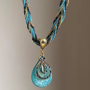 Gros plan d'un pendentif en turquoise avec filigrane d'or et cordon tressé chic