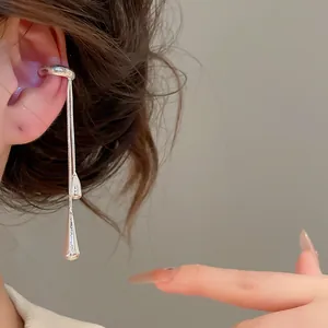 Close-up of silver water drop tassel ear cuff on model's ear showing elegant design