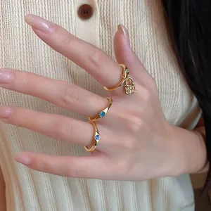 Detail shot of vintage gold rings featuring blue gemstones and hedonism charm on hand