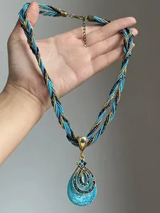 Détail du collier pendentif goutte avec cordon tressé bleu et accents de strass