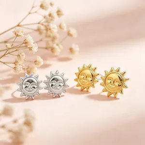 Gros plan détaillé de boucles d'oreilles soleil souriant en finitions or et argent