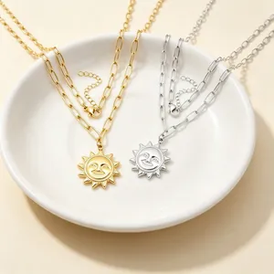 Détail rapproché de colliers avec pendentif soleil dorés et argentés sur céramique
