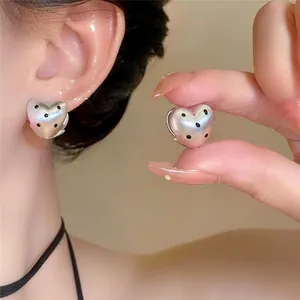 Orecchini a cuore argento con pois neri stile coreano, dettaglio ravvicinato e indossato.