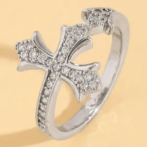 Macro detail of silver-colored double cross ring with shimmering crystal accents