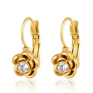 Détail de boucles d'oreilles fleur en acier doré avec centre en cristal scintillant