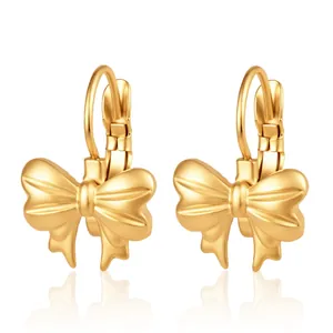 Gros plan d'élégantes boucles d'oreilles à clips en forme de nœud doré