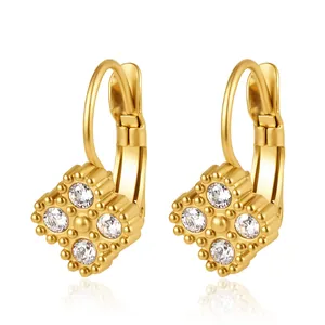 Gros plan de boucles d'oreilles dorées en acier inoxydable avec zircons carrés