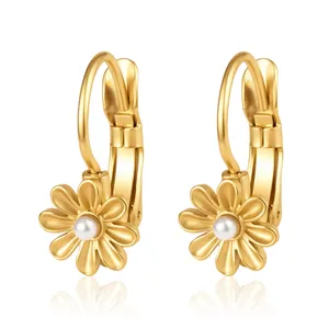 Détail de boucles d'oreilles fleur en acier doré avec perle blanche pour femmes