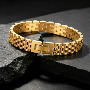 Gros plan d'un bracelet en acier inoxydable doré avec boucle à pression sur ardoise