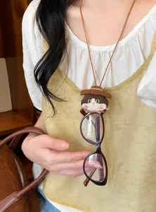 Close-up of a sweet fabric cat doll necklace used as a functional glasses holder on a model