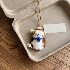 Close-up of a sweet handmade fabric cat doll necklace in a rustic presentation box