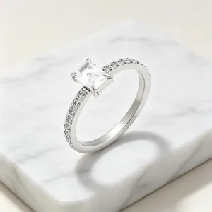 Detailopname van elegante ring met rechthoekige zirkoon en halfcirkelvormige diamanten zilver.