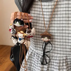 Close-up detail of cute fabric cat necklace used as a glasses holder on checkered dress
