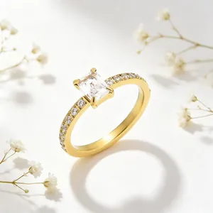 Detailopname van een gouden roestvrijstalen ring met zirkoon en bloemenachtergrond