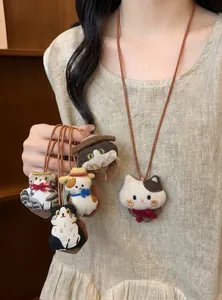 Close-up view of cute cat fabric plush necklaces with leather cords and bow details