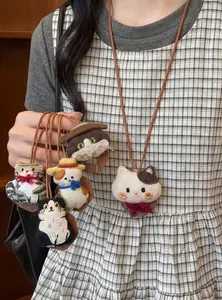 Close-up of handmade fabric cat doll necklaces on leather cords in various designs