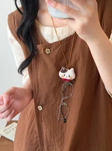 Close-up detail of a cute plush cat doll necklace functioning as a glasses holder.