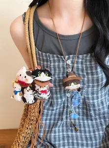 Detail view of a sweet handmade fabric cat doll necklace and eyewear holder on a model