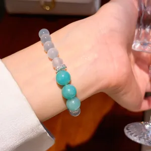 Primo piano di un bracciale di perle turchesi con distanziatori in zirconia portati al polso.