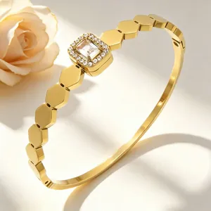 Detailaufnahme eines goldenen sechseckigen Armreifs mit quadratischem Herzstück