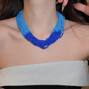 Detailed view of a multi-strand blue seed bead handmade necklace on an Asian model
