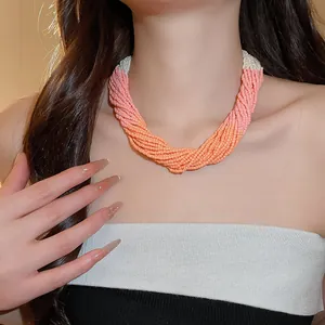 Detailed view of multi-layer handmade seed bead necklace in pink and orange tones