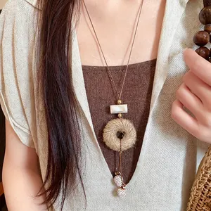 Handgemaakte bohemian ketting met hanger van jutetouw, houten kralen en bruin koord
